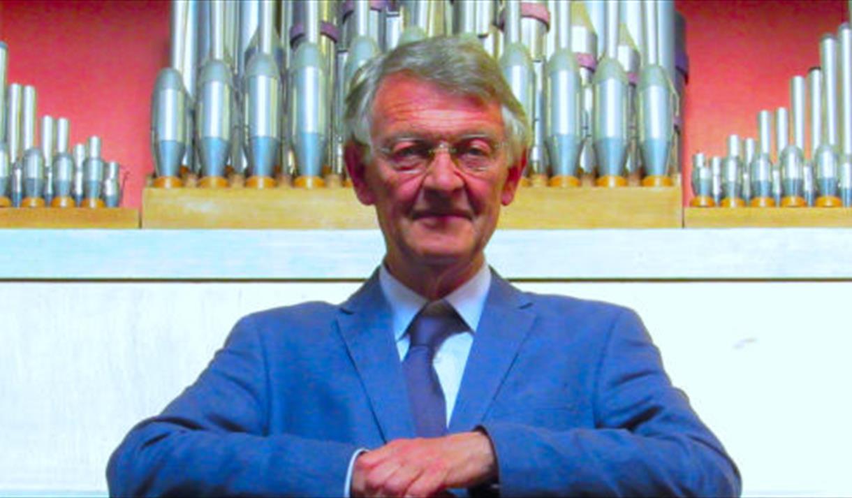 man in front of an organ
