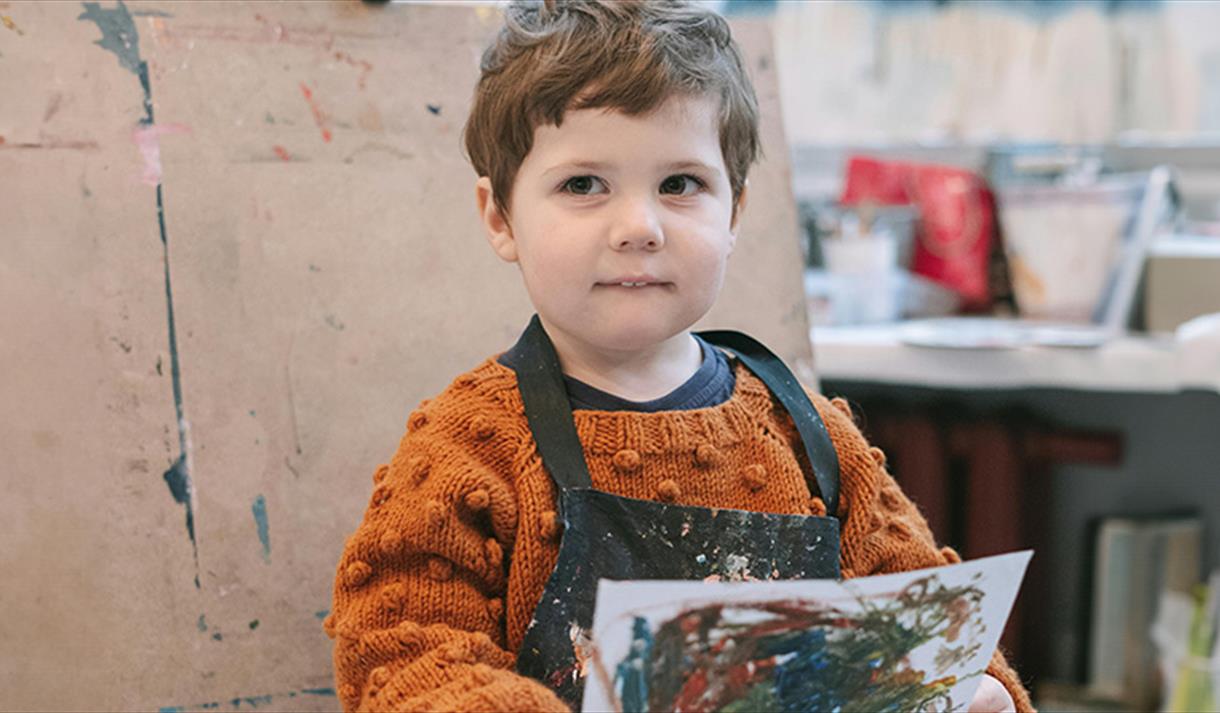 child with artwork they painted