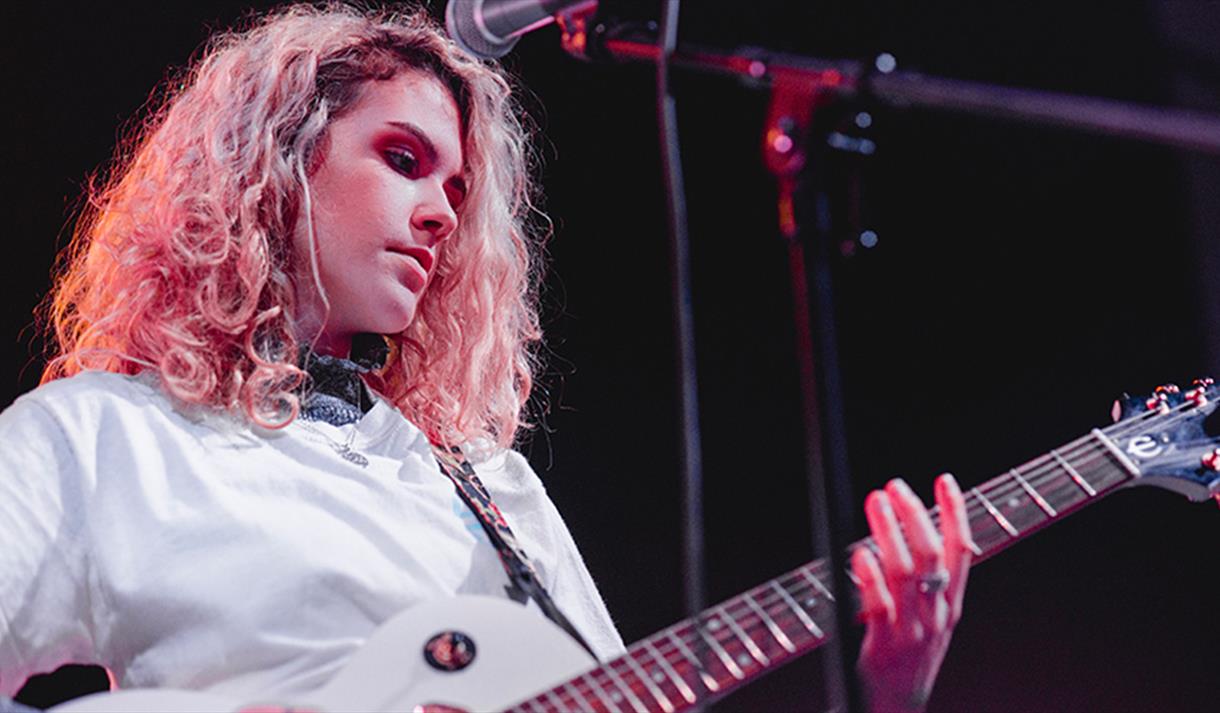 woman playing electric guitar