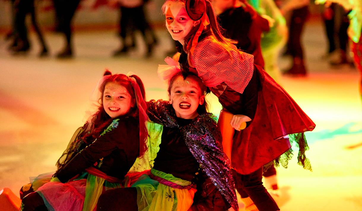 Photo of kids in fancy dress skating on the ice