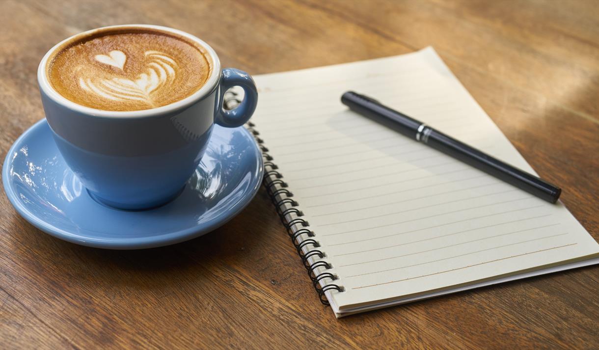 Photo of a blank notepad and a latte