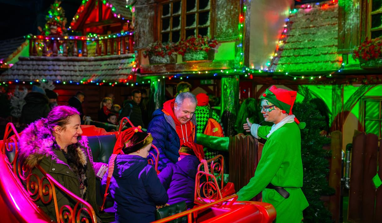 Photo of a family geting greeted by an elf