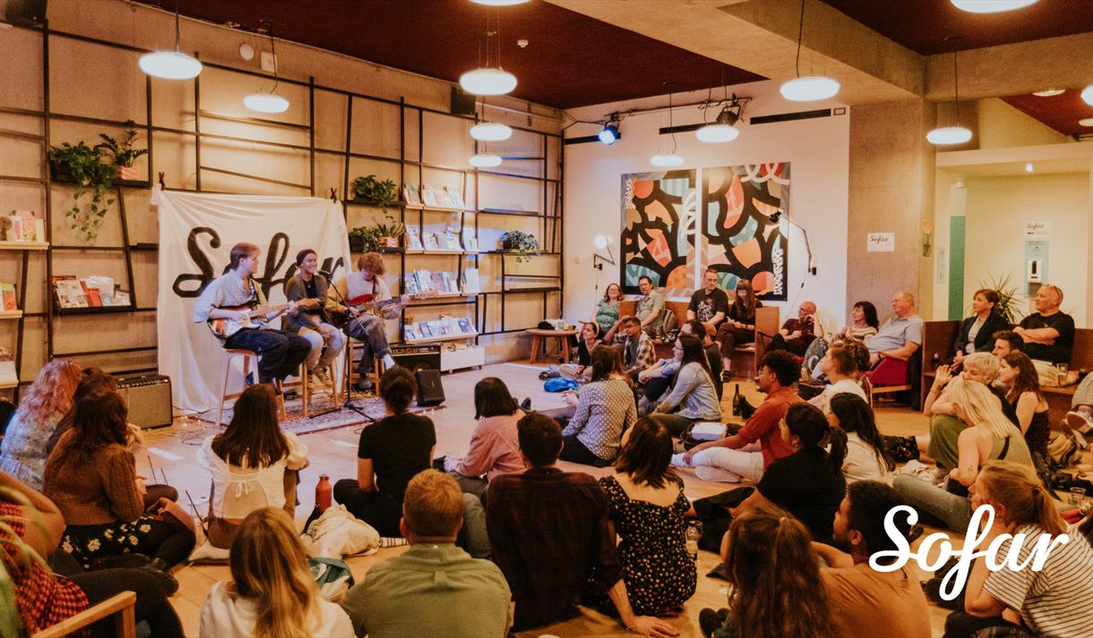 A trio of musicians play to a seated audience