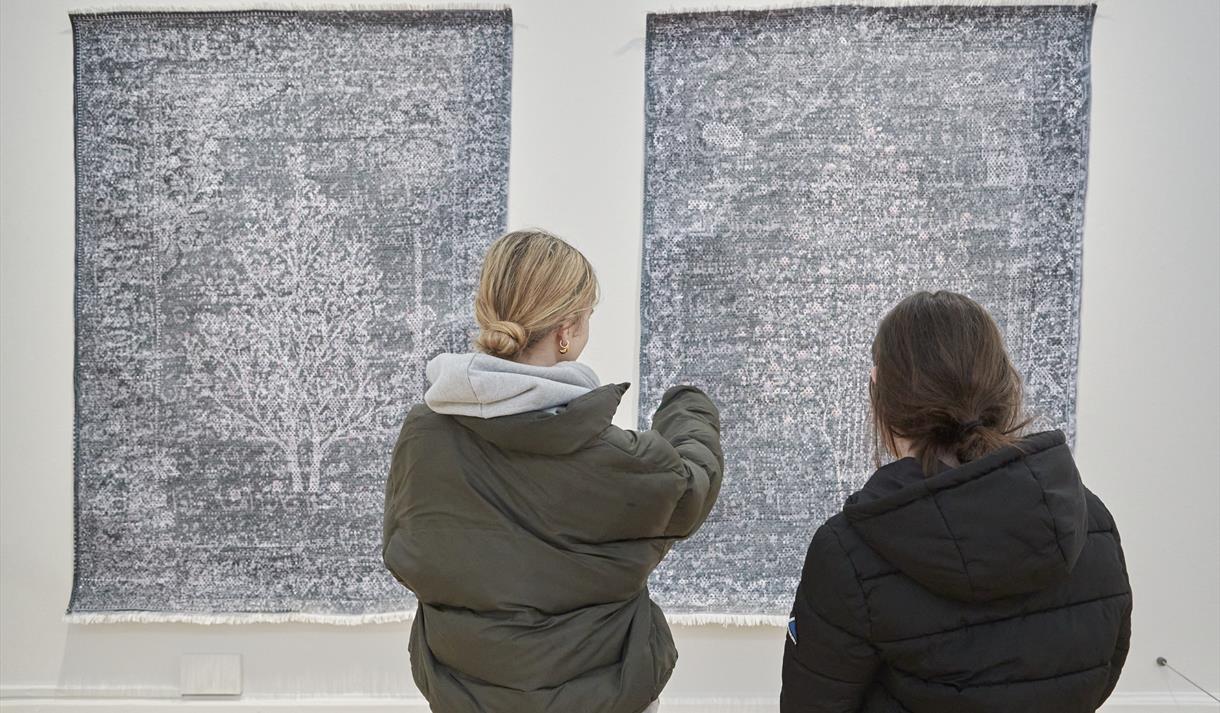 Photo of two people looking at the exhibition
