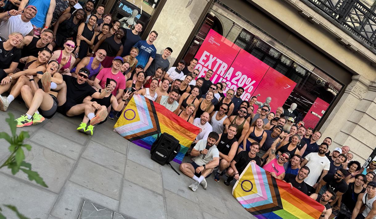 Group shot of participants in 5km run displaying Pride flags.