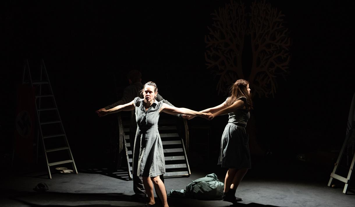 A photo of two performers on a bare stage.