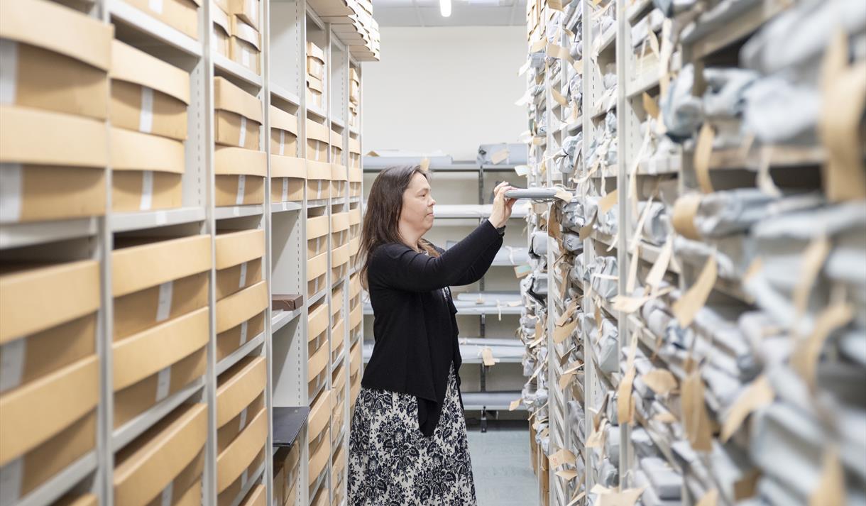 Member of staff moving documents in the store room