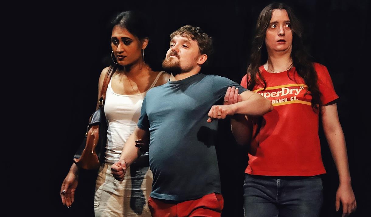 Image of two ladies escorting a young man away