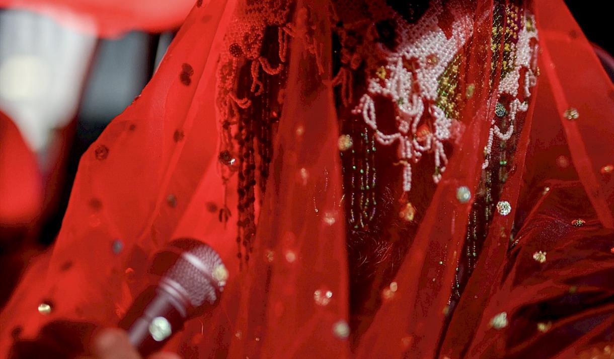 Photo of a veiled person talking into a microphone