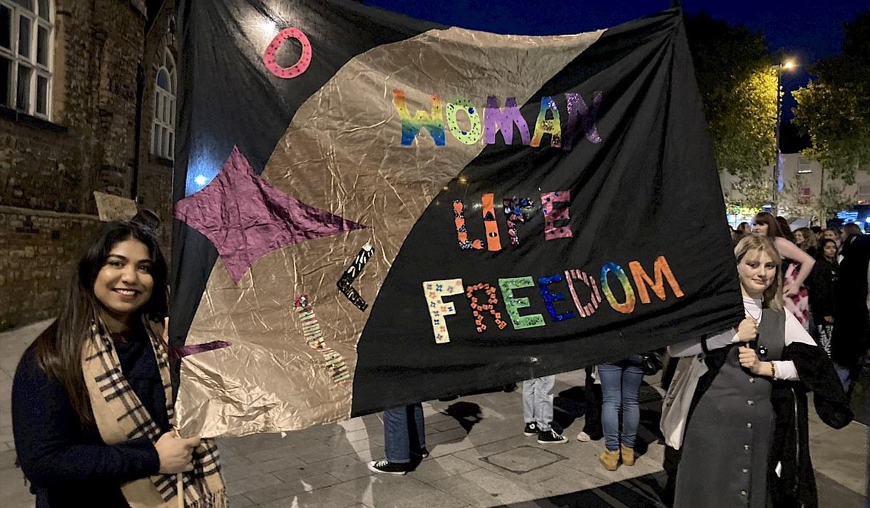 Two demonstrators hold up a banner protesting for women's rights
