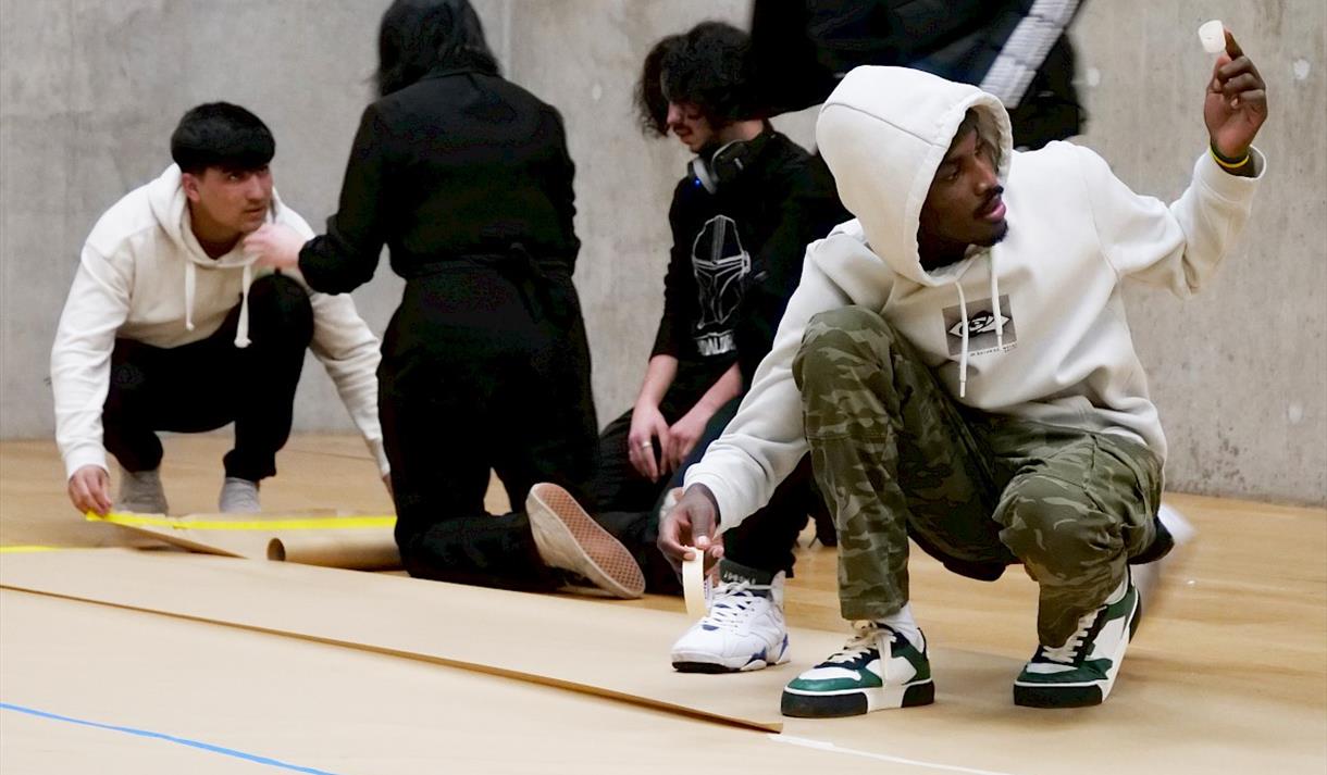 Photo of people engaging in the art, crouching on the floor