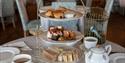 A photograph of an Afternoon Tea tower on an ornately dressed tabletop